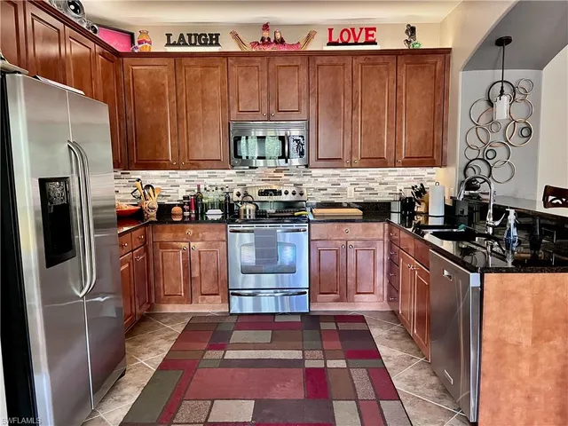 a kitchen with stainless steel appliances granite countertop a stove a sink dishwasher and a refrigerator