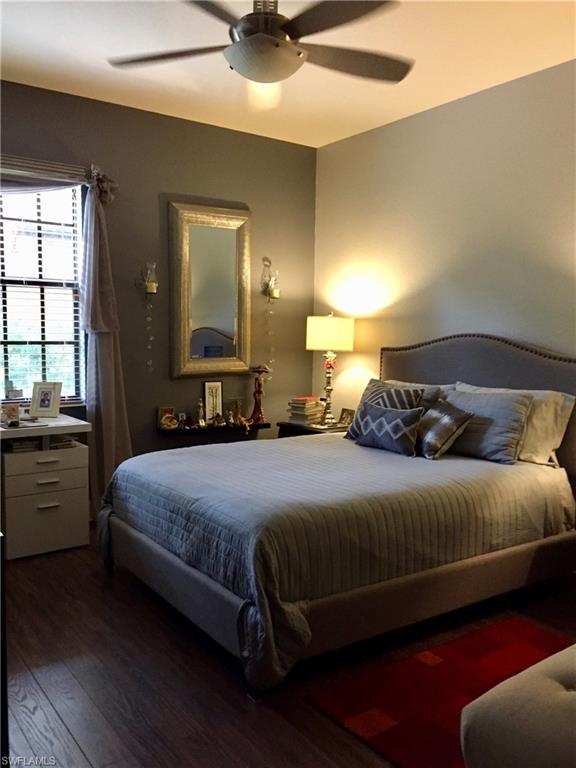 9126 Chula Vista Street, Unit 12301 Naples, FL 34113 - Photo 9 of 36 a bedroom with a bed and a chandelier