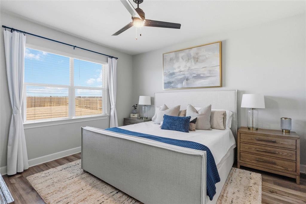 1012 Calhoun Drive Anna, TX 75409 - Photo 19 of 39 Bedroom featuring wood-finish flooring, a large window with blinds and white curtains, and a ceiling fan