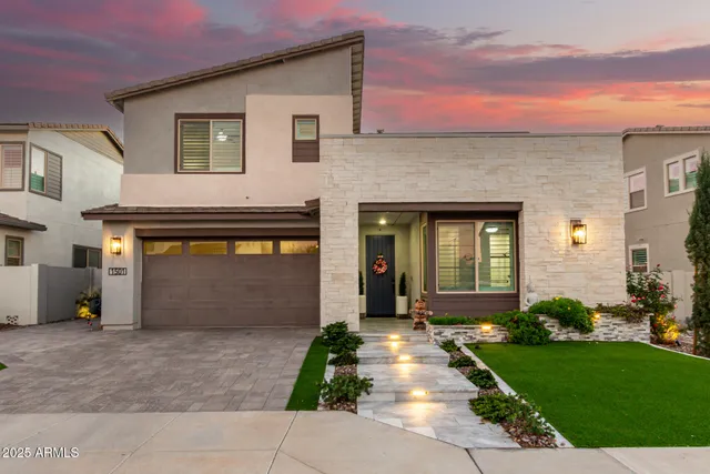 a front view of a house with a yard and potted plants