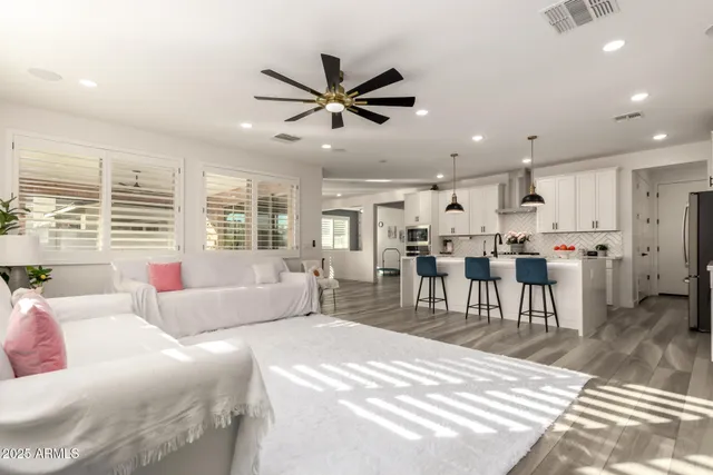 a living room with stainless steel appliances furniture and a flat screen tv
