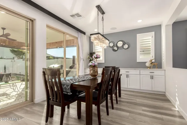 a kitchen with stainless steel appliances a dining table chairs stove refrigerator and cabinets