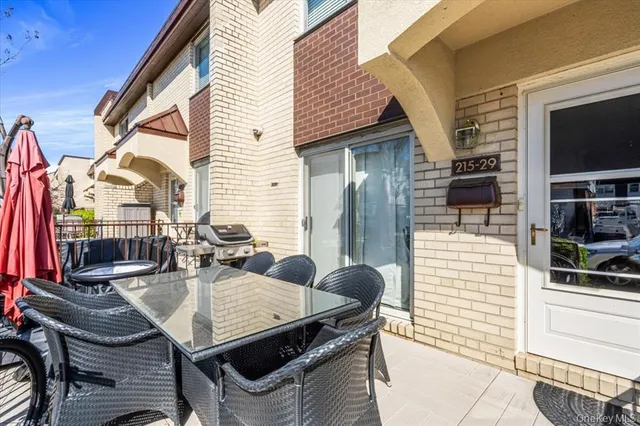 a kitchen with stainless steel appliances granite countertop a dining table chairs refrigerator and sink