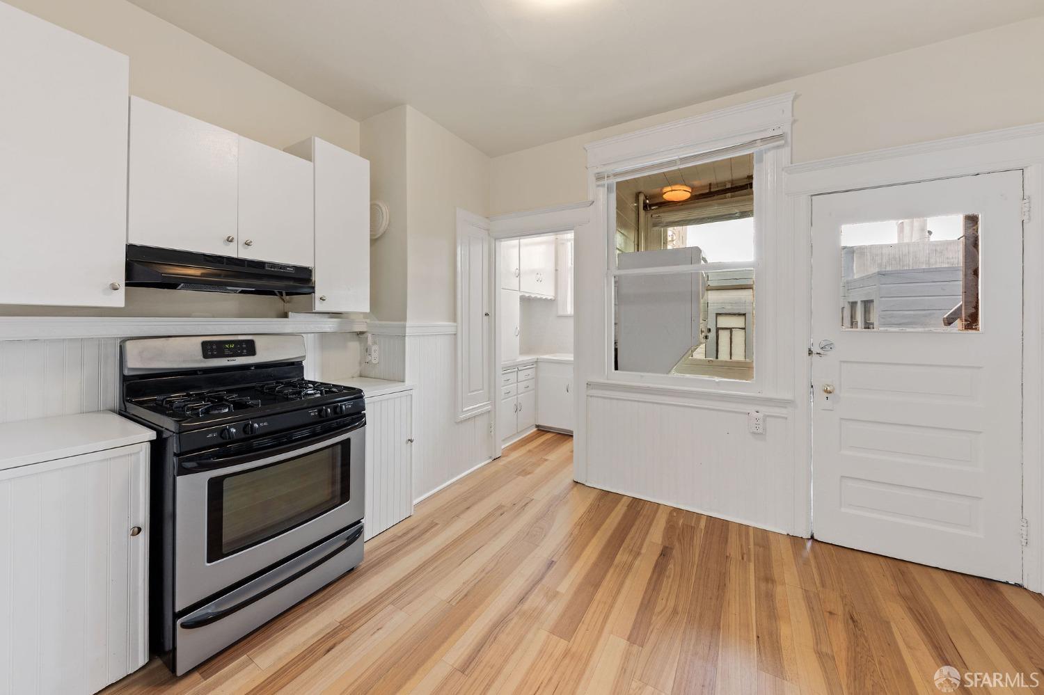 58-60 Valparaiso Street, Unit 2 San Francisco, CA 94133 - Photo 27 of 79 a kitchen with white cabinets and a stove top oven