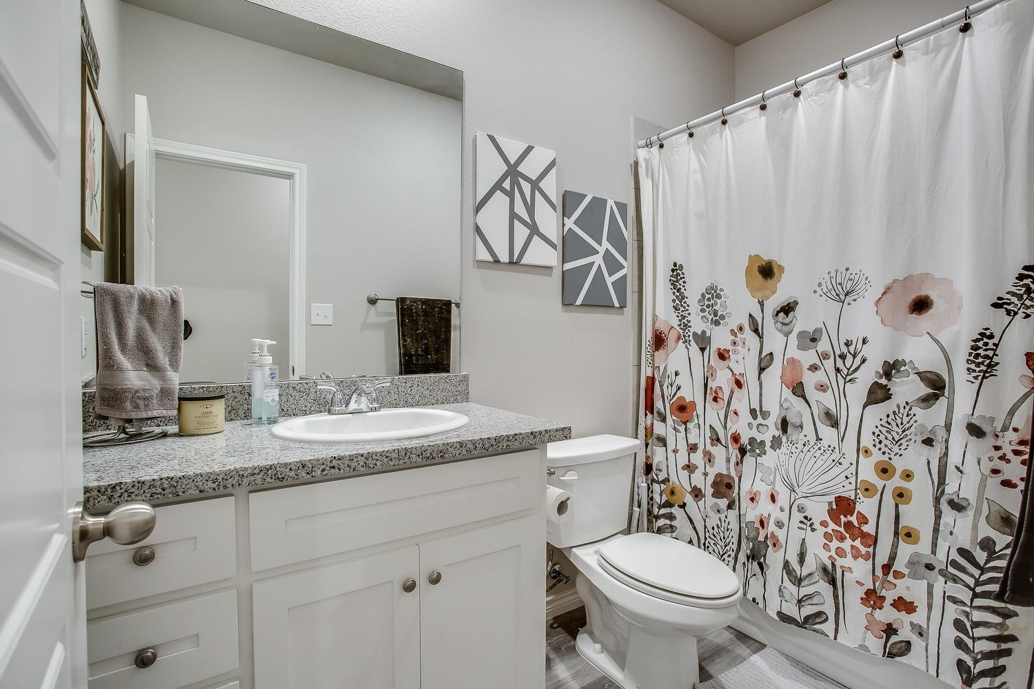 7017 10th Street Lubbock, TX 79416 - Photo 13 of 16 a bathroom with a granite countertop sink and a mirror