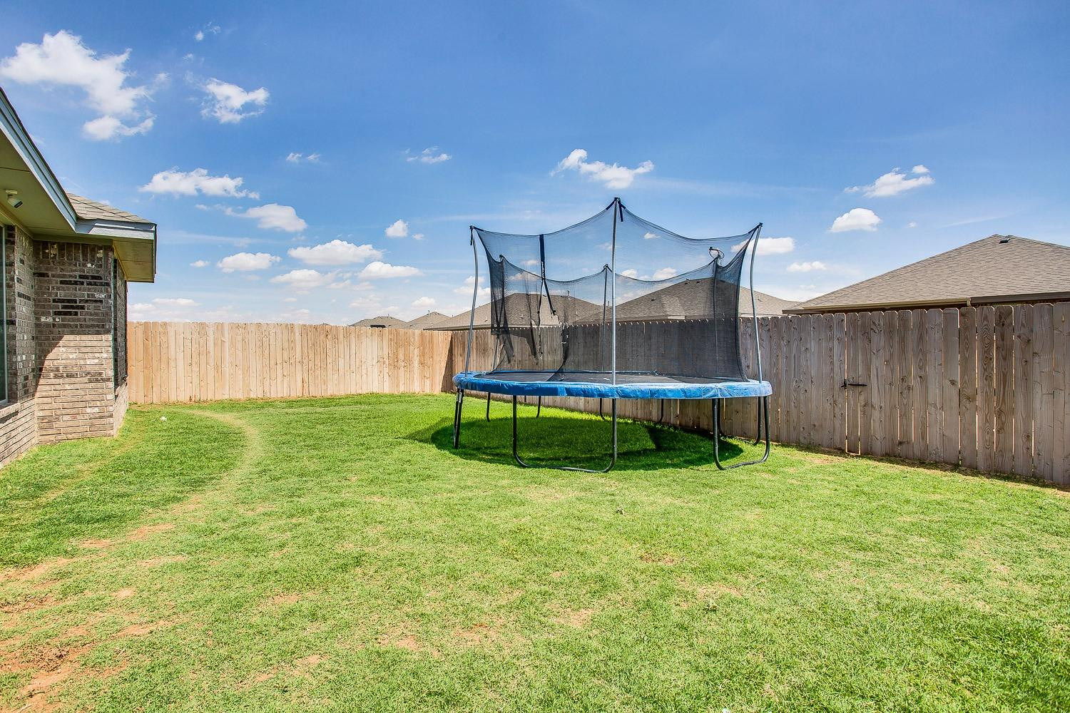 7017 10th Street Lubbock, TX 79416 - Photo 16 of 16 a view of a house with backyard and a patio