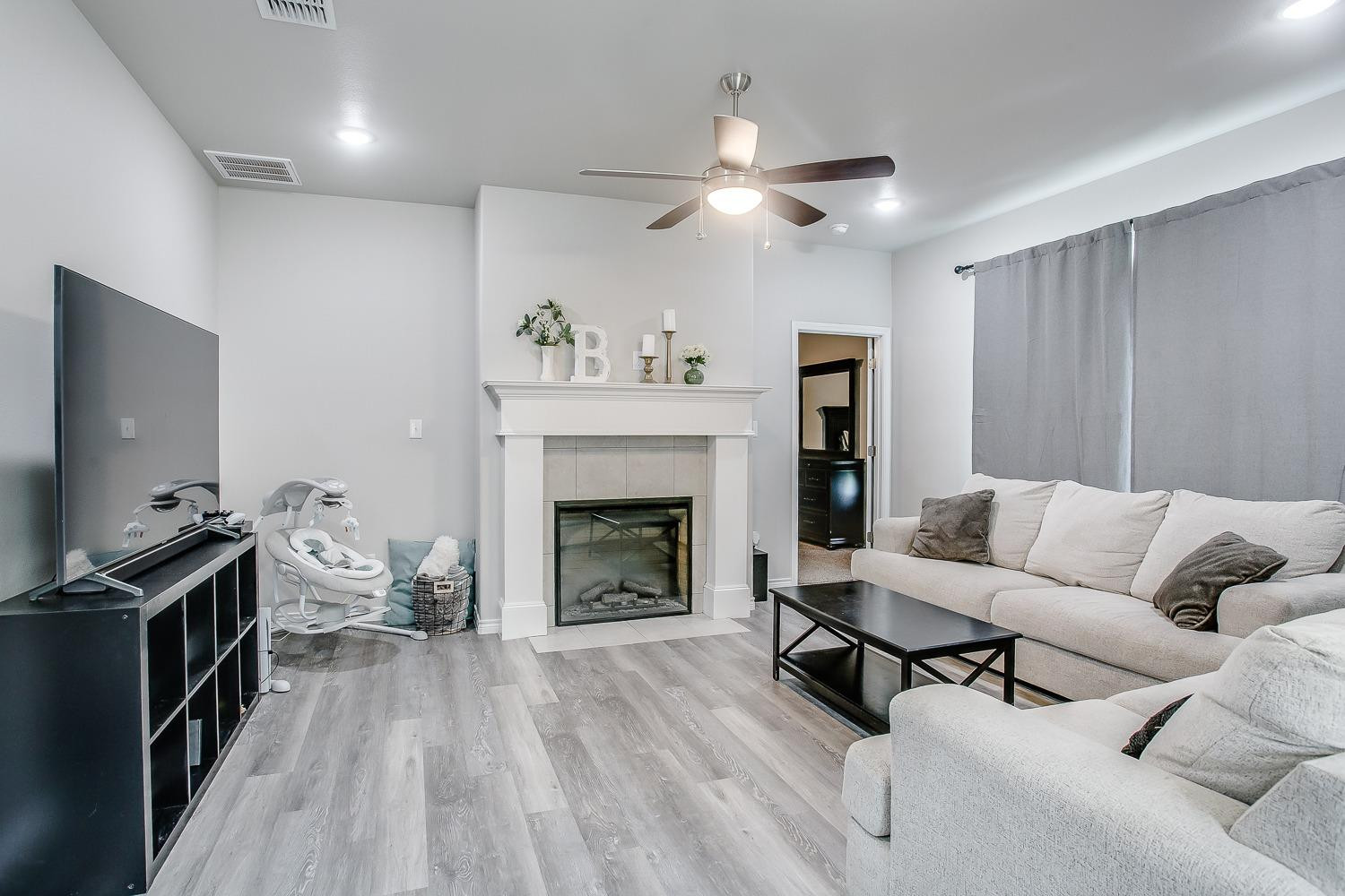 7017 10th Street Lubbock, TX 79416 - Photo 2 of 16 a living room with furniture and a fireplace