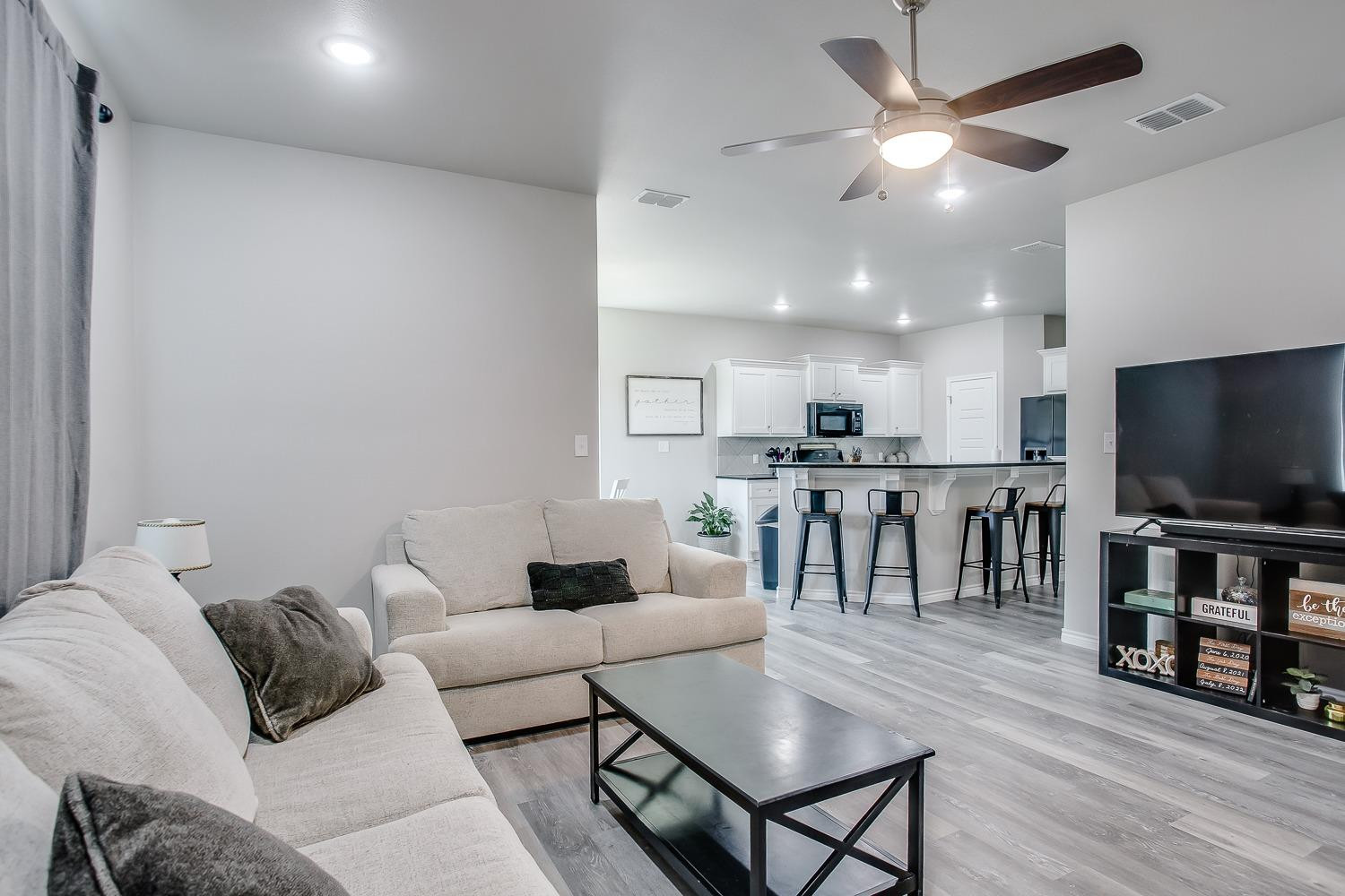 7017 10th Street Lubbock, TX 79416 - Photo 3 of 16 a living room with furniture and a flat screen tv
