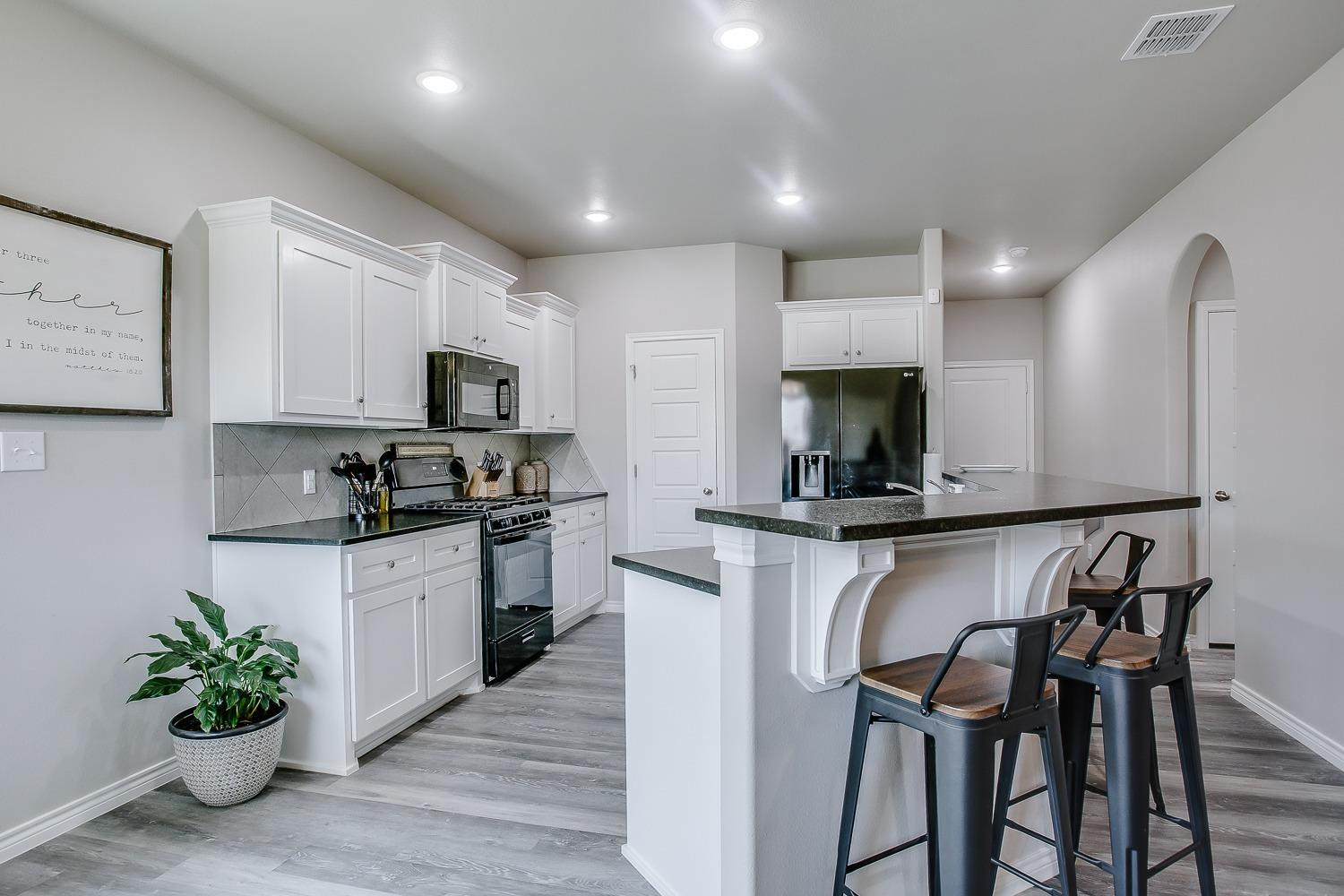 7017 10th Street Lubbock, TX 79416 - Photo 4 of 16 a kitchen with white cabinets and stainless steel appliances