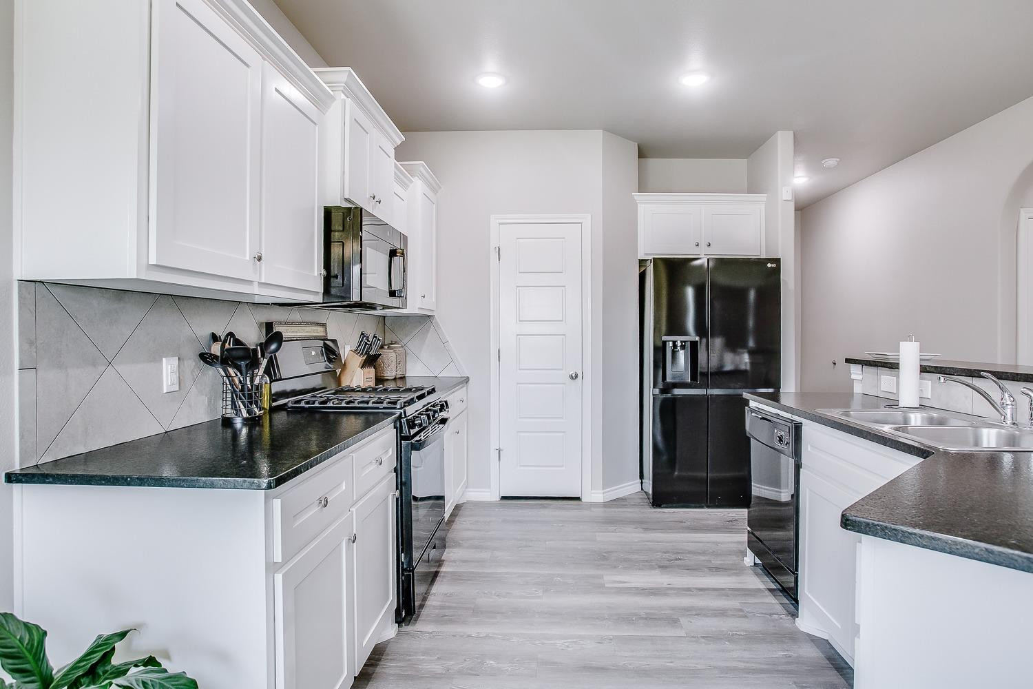 7017 10th Street Lubbock, TX 79416 - Photo 5 of 16 a kitchen with stainless steel appliances granite countertop a sink stove and refrigerator