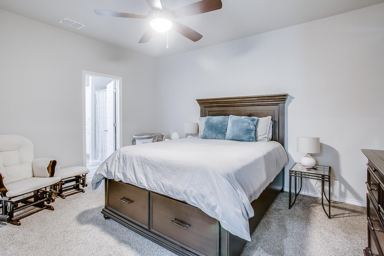 7017 10th Street Lubbock, TX 79416 - Photo 10 of 16 a bedroom with a bed and a chandelier
