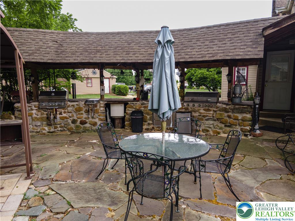 2485 Hieter Road Quakertown, PA 18951 - Photo 82 of 97 An inviting stone patio offers a covered outdoor kitchen, perfect for alfresco dining and entertaining.