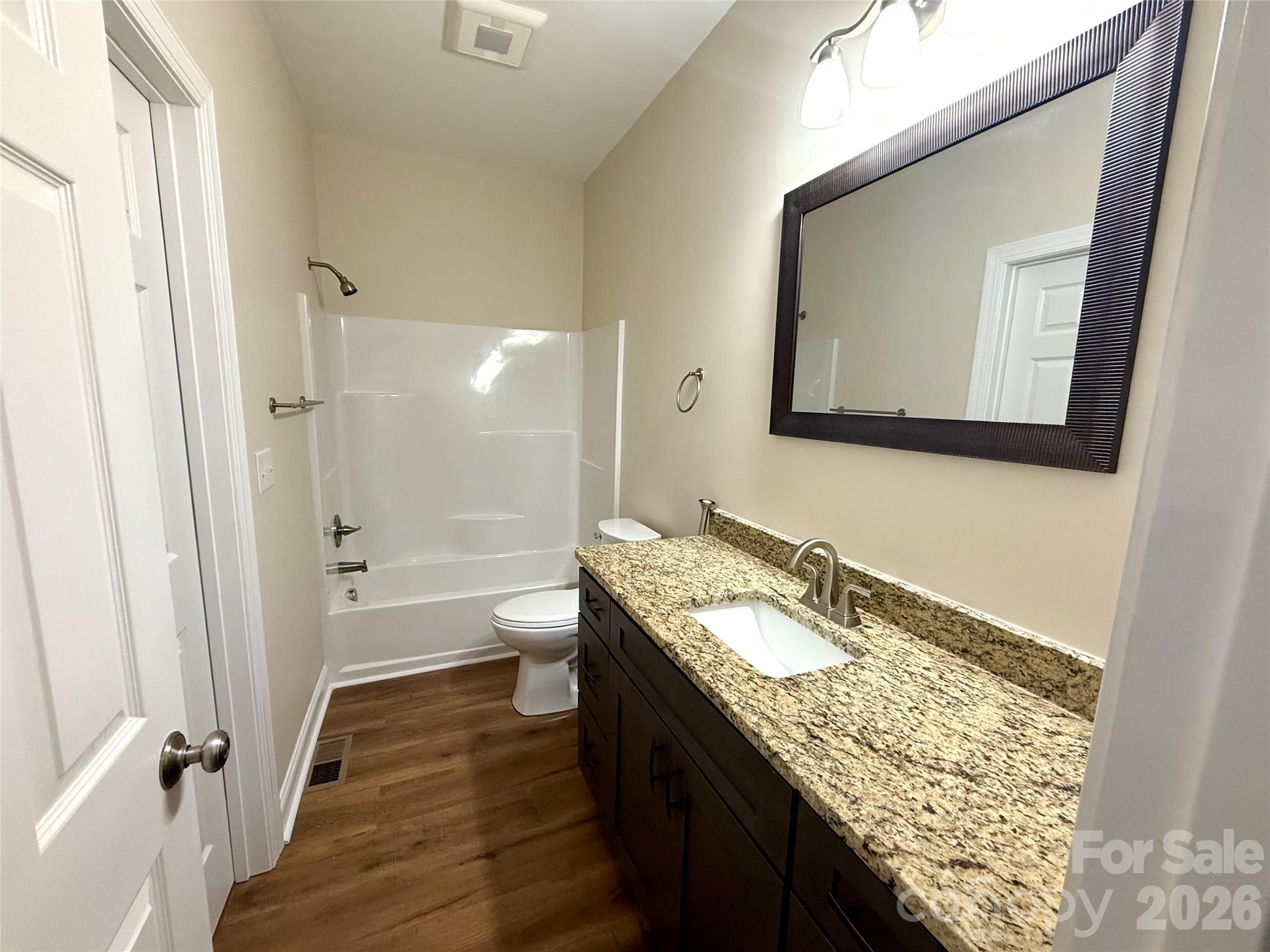 341 Broad Drive Southwest Concord, NC 28025 - Photo 13 of 16 a bathroom with a granite countertop toilet a sink and a mirror