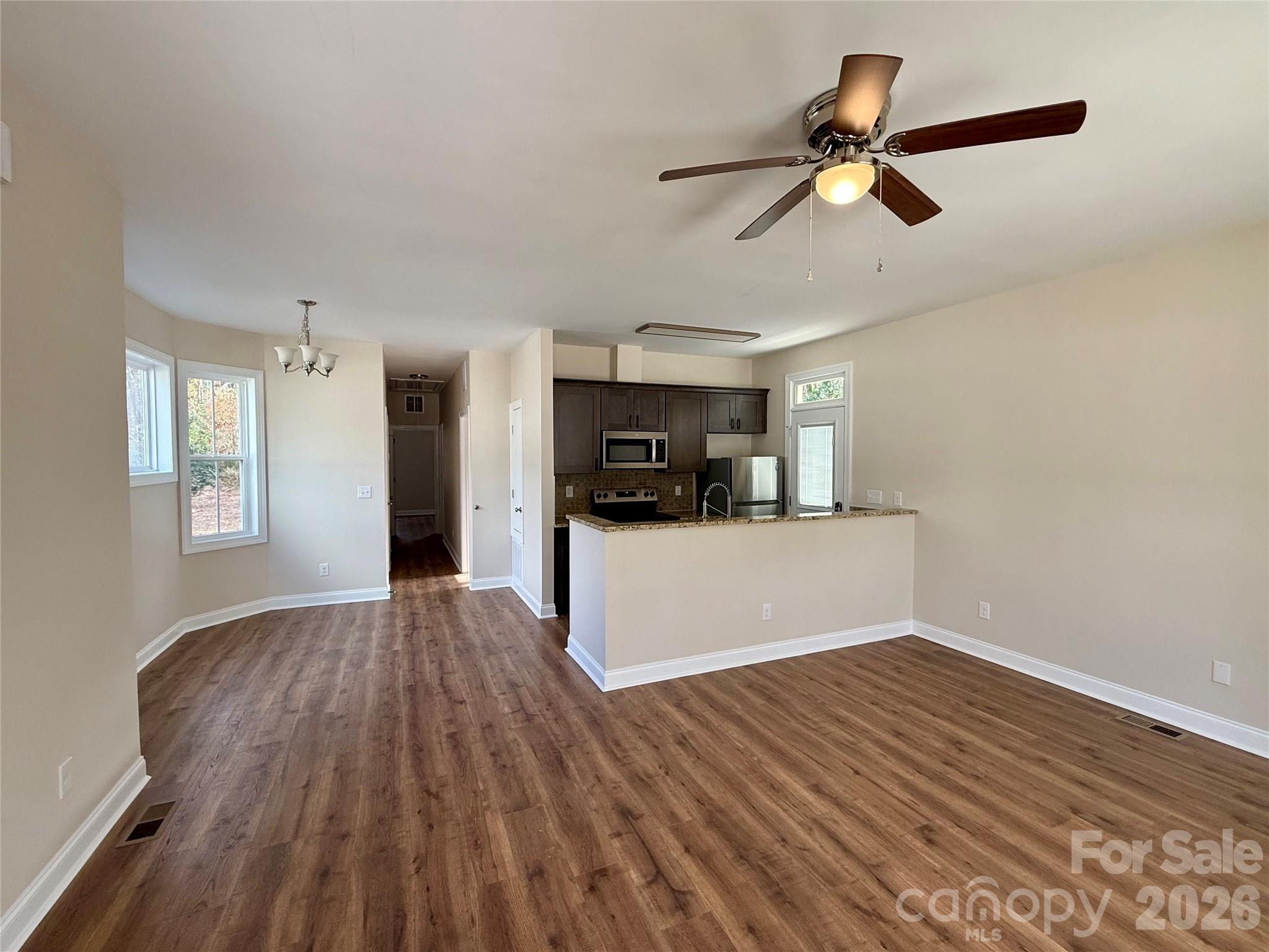 341 Broad Drive Southwest Concord, NC 28025 - Photo 3 of 16 a view of a room with wooden floor and a ceiling fan