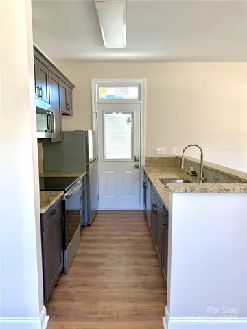a kitchen with granite countertop a sink and a stove top oven