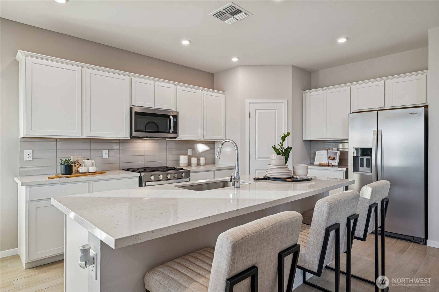 9816 Ferns Loop Southeast Yelm, WA 98597 - Photo 6 of 20 a kitchen with a stove a refrigerator and a dining table