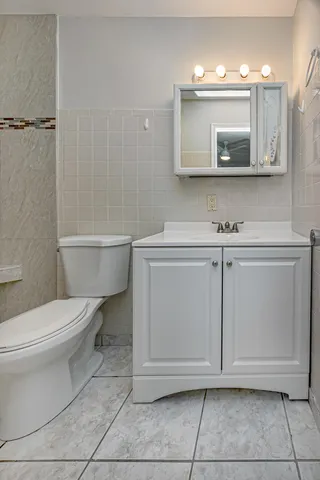 a bathroom with a toilet a sink and mirror