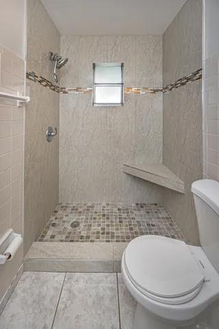 a bathroom with a toilet and a shower