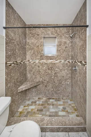 a bathroom with a toilet and a shower