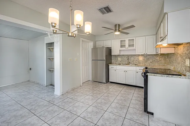 a kitchen with a sink a counter top space cabinets and stainless steel appliances