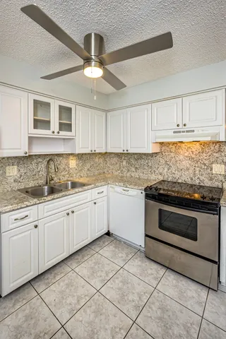 a kitchen with granite countertop cabinets stainless steel appliances and a sink