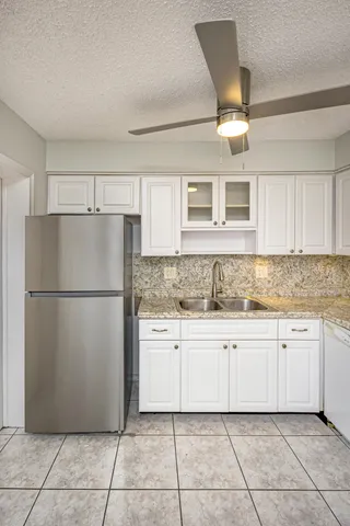 a kitchen with granite countertop a refrigerator and a sink