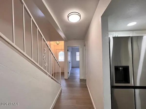 a view of a hallway with wooden staircase and wooden floor