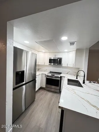 a kitchen with stainless steel appliances a refrigerator sink and microwave