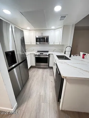 a kitchen with stainless steel appliances a refrigerator a sink a stove a microwave and cabinets