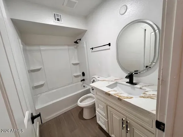 a bathroom with a granite countertop sink mirror vanity and toilet