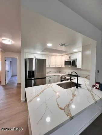 a living room with stainless steel appliances kitchen island granite countertop furniture and a view of kitchen