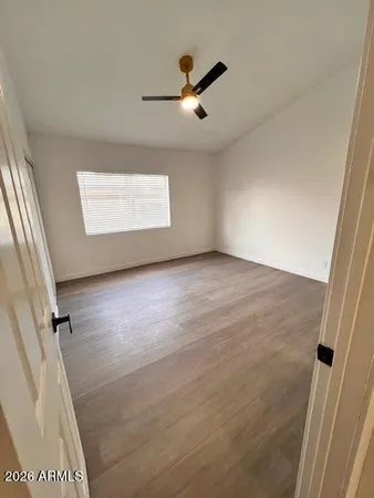 an empty room with wooden floor and windows