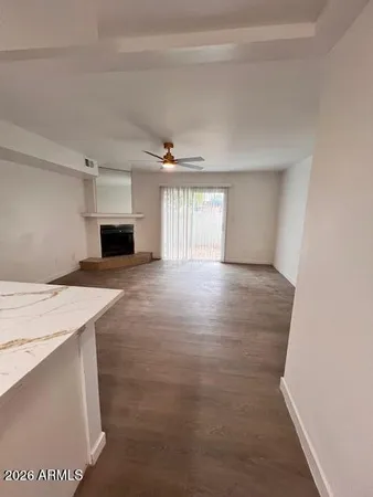 a view of empty room with wooden floor and window