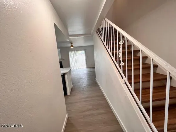 a view of staircase with wooden floor and white walls