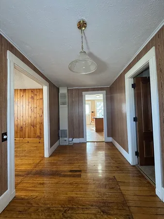 a view of an empty room with window and wooden floor