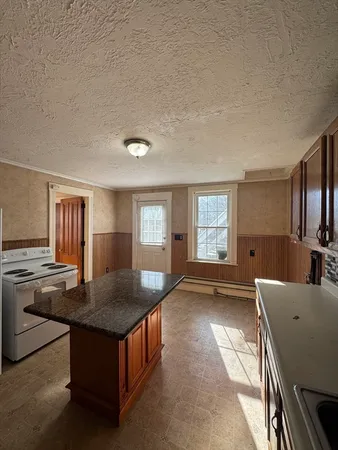 a living room with stainless steel appliances granite countertop furniture and a kitchen view
