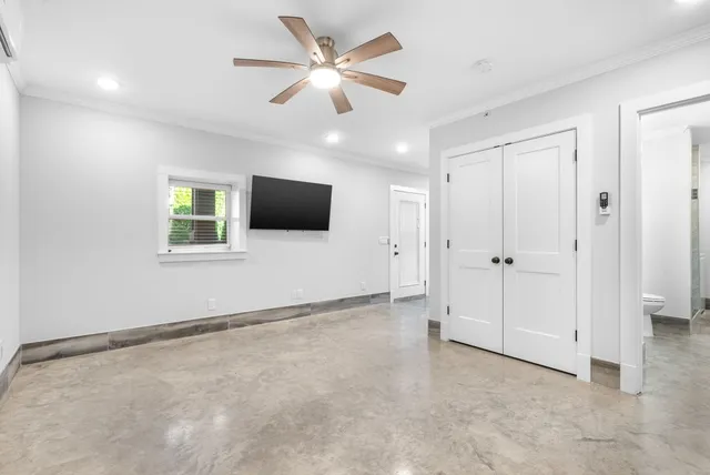 an empty room with windows and ceiling fan
