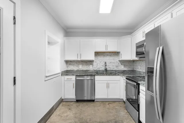 a kitchen with stainless steel appliances granite countertop a stove a refrigerator and a sink