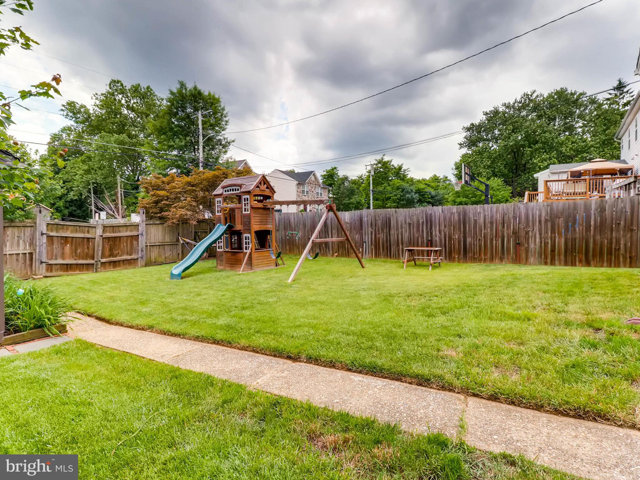 604 Coleraine Road Catonsville, MD 21229 - Photo 28 of 30 a view of a backyard with a slide trees and wooden fence