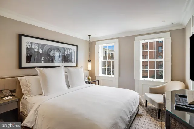 a bedroom with a bed and a large window