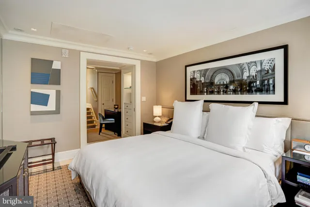 a bedroom with a large bed and a painting on the wall