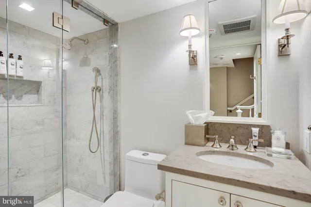 a bathroom with a granite countertop sink toilet and shower