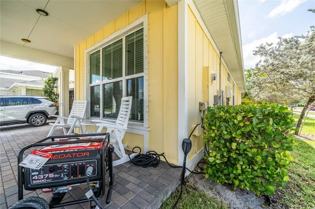 a view of a house with a cars park side of a road