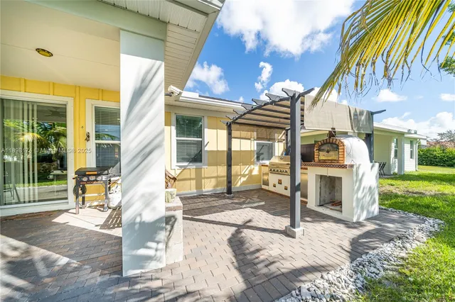 a view of a house with a patio and a yard