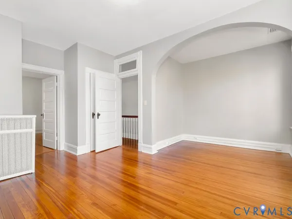 a view of a livingroom with wooden floor and a fireplace