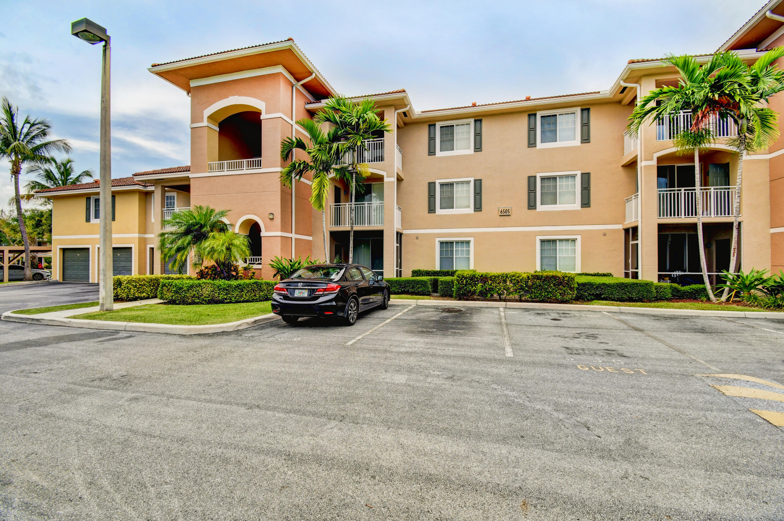 6505 Emerald Dunes Drive, Unit 201 West Palm Beach, FL 33411 - Photo 1 of 44 a view of a street with a house