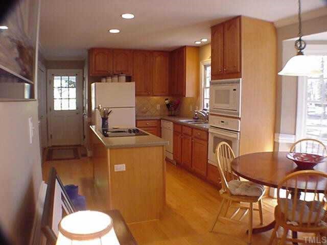 8804 Wellsley Way Raleigh, NC 27613 - Photo 4 of 10 a room with a chair a sink and a dining table with wooden floor