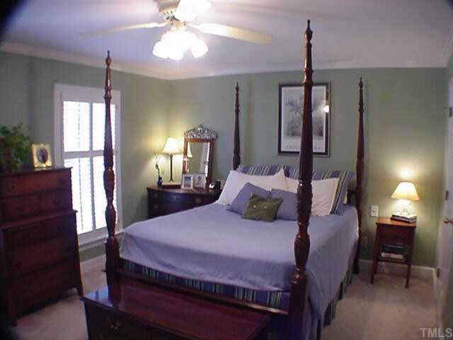 8804 Wellsley Way Raleigh, NC 27613 - Photo 5 of 10 a bedroom with a bed a chandelier and window