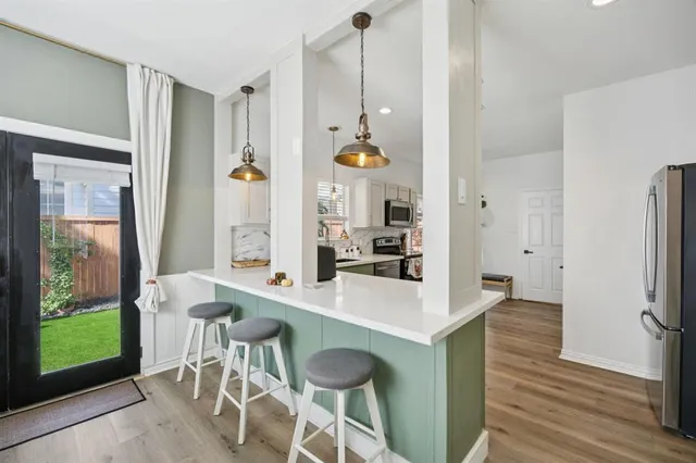 a dining hall with a dining table chairs with wooden floor and windows