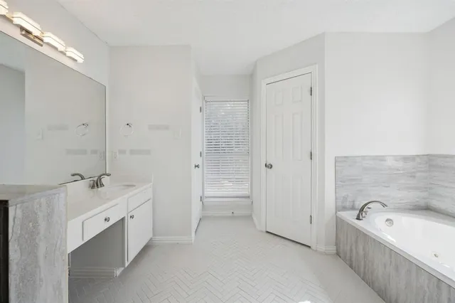 a bathroom with a tub sink and mirror